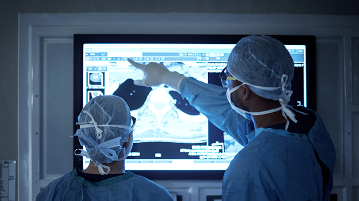 Doctors looking at x-ray images on a monitor.